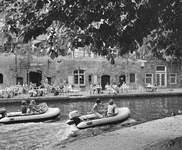857126 Gezicht op de Oudegracht te Utrecht, met enkele rubberbootjes en op de achtergrond het terras op de werf van ...